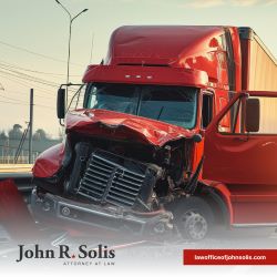 A red truck with severe front end damage following a Laredo truck accident